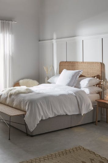 a rattan bed in neutral tones
