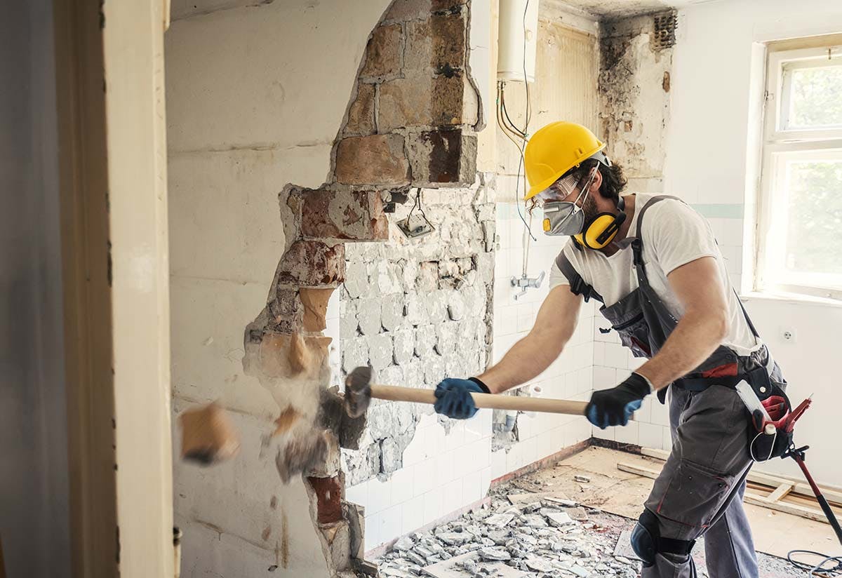 worker with hammer renovating a house